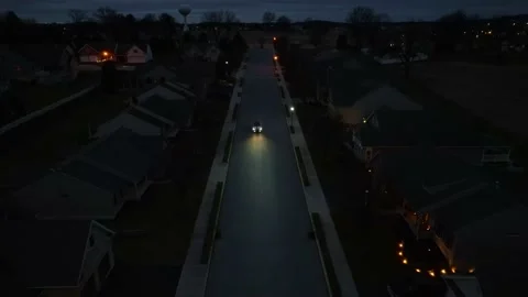 Aerial view of car driving through dark American neighborhood at night. Stock Footage 231462409