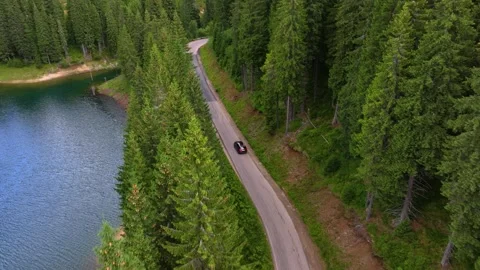 Aerial view of car driving through the forest and the lake on the side. Stock-Footage 248048701