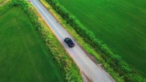 Aerial View: Car on Mud Road Between Fields Stock Footage 256010681