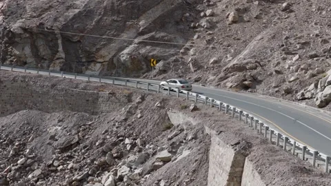 Aerial view of a car navigating a winding mountain road in Pakistan Stock Footage 314455292