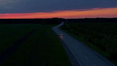Aerial view of a car on the road on the background of sunset Stock-Footage 167099178