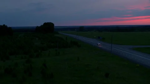 Aerial view of a car on the road on the background of sunset Stock Footage 168575377