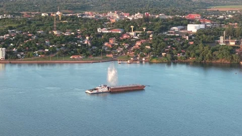 Aerial view of cargo barge sailing near urban riverfront, Paraguay Stock Footage 311423450