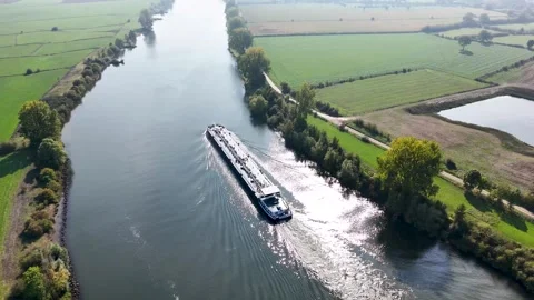 Aerial view of a cargo barge sailing on a river through countryside Видео 320813301