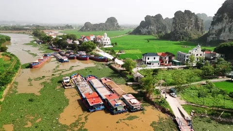 Aerial view of cargo barges on a river in ninh binh with karst mountains an.. Video stock 335088432