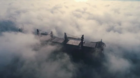 Aerial view of cargo container  ship sails in sea fog, crane vessel working Stock Footage 121351333
