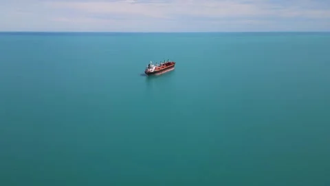 Aerial View of Cargo Ship Anchored in Calm Turquoise Sea Vídeo Stock 338995477