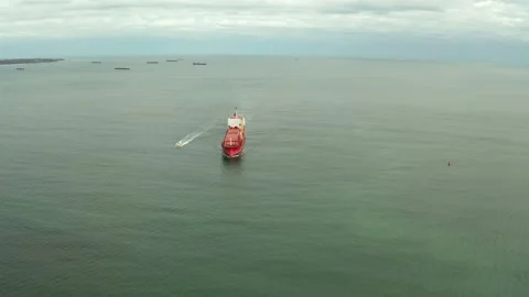 Aerial view of cargo ship calling into the port under the guide of tugboat. Stock-Footage 154468582