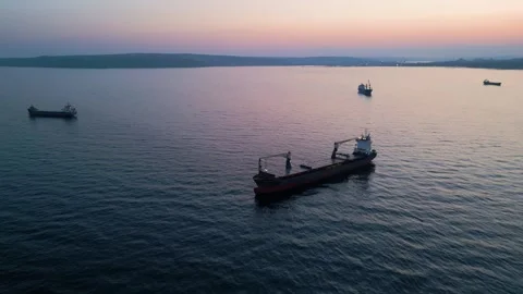 Aerial view of cargo ship on calm sea at sunset Video stock 331801680