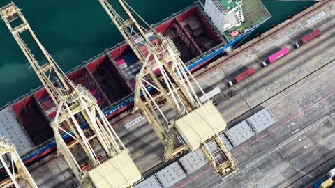 Aerial View of Cargo Ship Docked at Port with Cranes and Loading Area Stock Footage 340830825