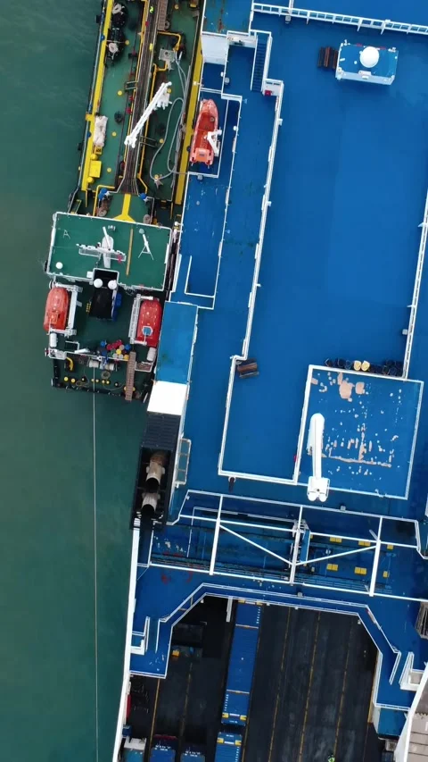 Aerial view of cargo ship docked at port with tanker refueling Stock Footage 343992618