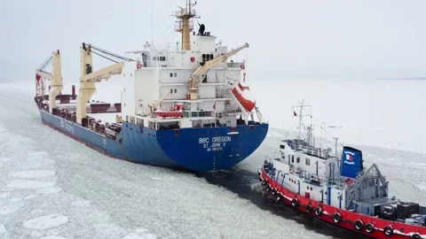 Aerial view Cargo ship goes through frozen ice covered fairway. Stock Footage 170385342