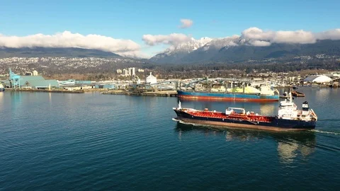 Aerial view of a cargo ship sailing out of a harbor Stock Footage 103732473