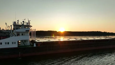 Aerial view. A cargo ship sails on the river at sunset. Transportation of goods. 動画素材 234648157