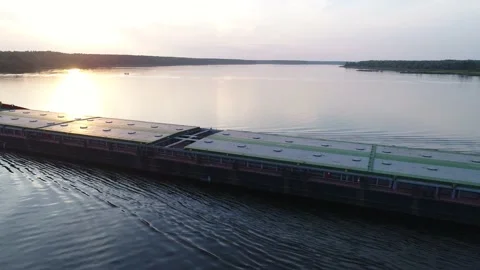 Aerial view. A cargo ship sails on the river at sunset. Transportation of goods. 스톡 동영상 235572339