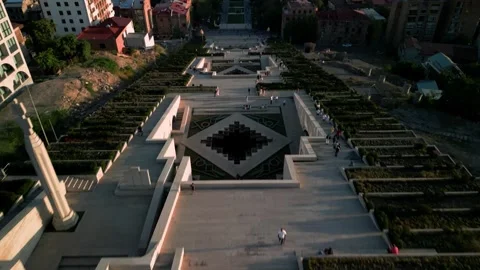 Aerial view of the Cascade Monument, evening sun rays, people walking along the  Stock Footage 250422883