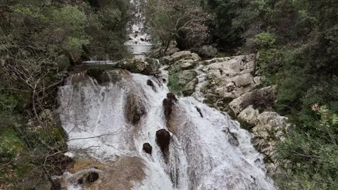 Aerial View of cascade rushes down the rocky cliffs near Polylimnio Waterfall in 스톡 동영상 303189092