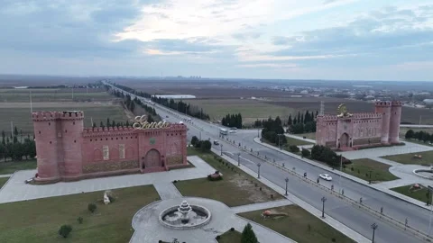 Aerial view of castle-like structures flank a long highway at dusk Stock Footage 341881985