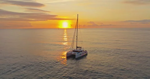 Aerial view of catamaran anchored in the calm sea at amazing sunset Video stock 328235053