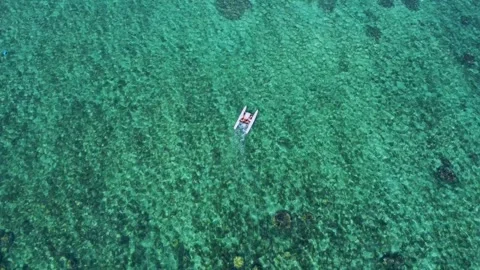 Aerial view of a catamaran floating over coral reefs in the Indian ocean Stock Footage 291621405