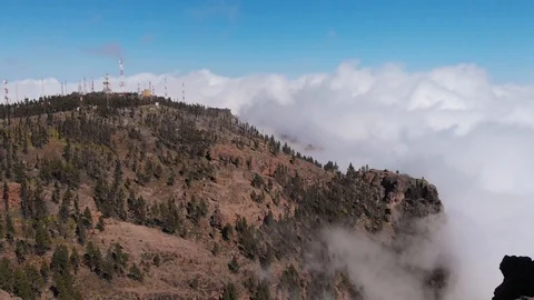 Aerial view - cell tower in the mountains, above the clouds, around the pine Stock Footage 113229285