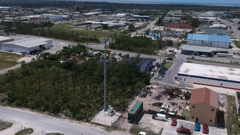 Aerial View of Cell Tower Surrounded by Industrial Businesses in Bahamas Stock Footage 90105637