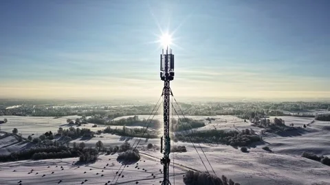 Aerial view cellular tower bright sun background falling snow winter Latvia Stock-Footage 331037462