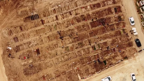 Aerial view of a cemetery with rows of graves and dirt roads. Stock Footage 258681852