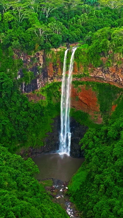 Aerial view of Chamarel Waterfall, plunging from verdant cliff into shadowy 库存影片 343466532
