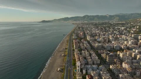 Aerial View: A charming seafront villa complex boasts a crystal-clear pool and Stock Footage 296036059