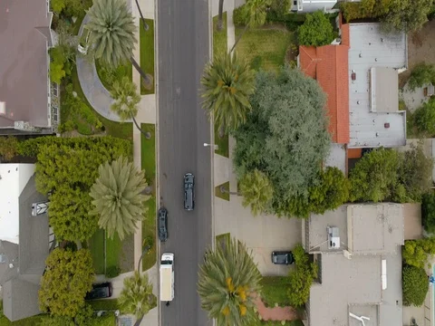 Aerial view of Chasing a car on Beverly Hills road with palms Video stock 75360424