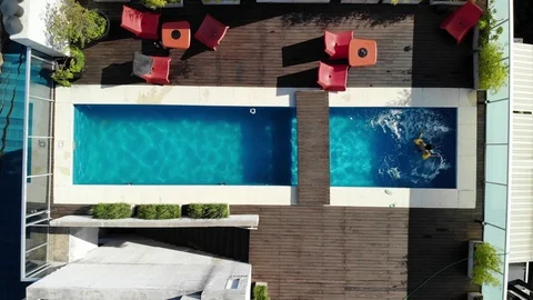 Aerial view of a child playing alone in a pool due coronavirus lockdown. Stock Footage 126501632