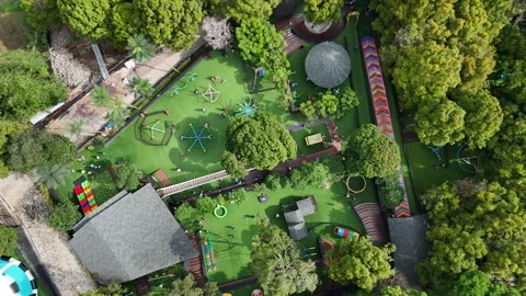 Aerial View of Children's Playground Surrounded by Lush Trees Stock Footage 338429306