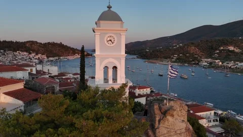 Aerial view circle pan right around famous clock tower and Greek flag during Stock Footage 328618355