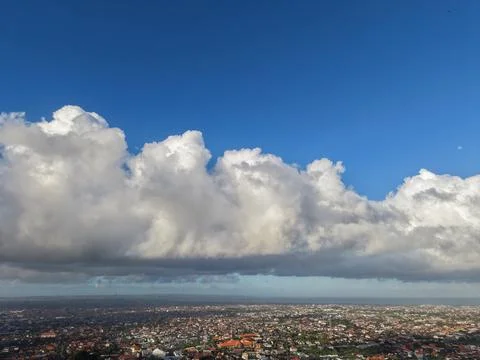 Aerial View of Cityscape Under Dramatic Cumulus Clouds and Blue Sky Stock-Fotos