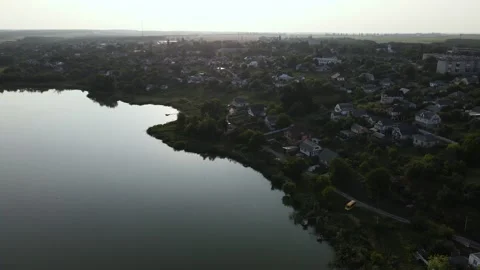Aerial view of Clear Reflection Lake in Valley near to Hills, Village, Sunset Stock Footage 162622199