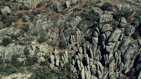 Aerial view of a cliff side enveloped in rocks resembling a stone wall. Stock Footage 149989014