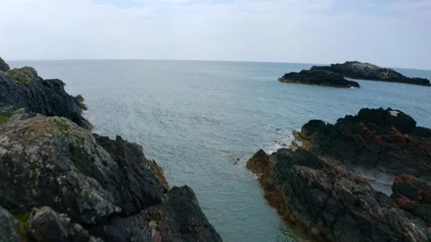Aerial View of cliff side rocks fading away to the ocean in North Wales uk 4k Stock Footage 177625542