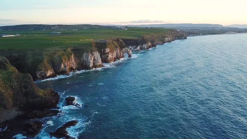 Aerial view of cliffs with arch during sunset in Northern Ireland Stock Footage 89871263