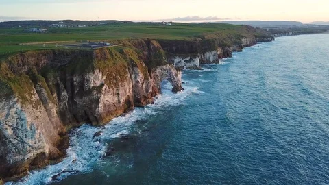 Aerial view of cliffs with arch during sunset in Northern Ireland Stock Footage 89871345