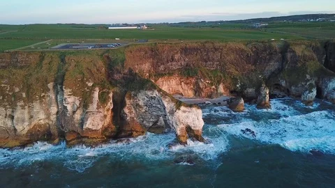Aerial view of cliffs with arch during sunset in Northern Ireland Stock Footage 89871375