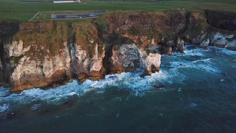 Aerial view of cliffs with arch during sunset in Northern Ireland Stock Footage 89871383