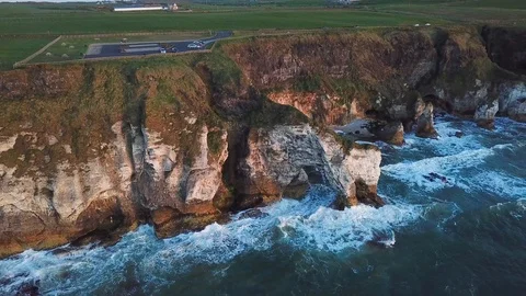 Aerial view of cliffs with arch during sunset in Northern Ireland Stock Footage 89871408
