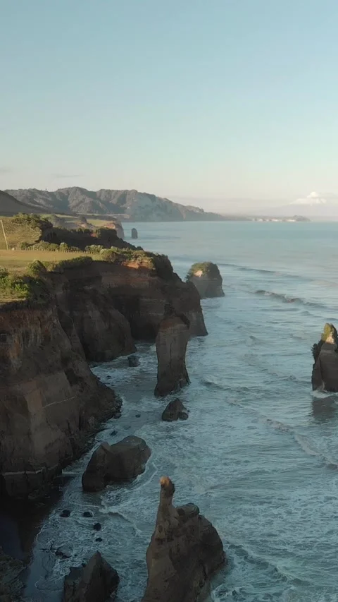 Aerial view of cliffs with beautiful rock formations by the sea at sunset. .. Stock Footage 288504316
