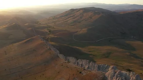 Aerial view of cliffs mountains and road at sunset Stock Footage 294103248
