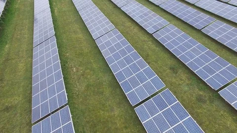 Aerial view  Close up flight over solar panels modules on green meadow Stock Footage 75467078
