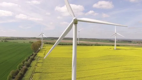 Aerial view close up of wind turbine propeller blades in yellow canola field Stock Footage 75485792