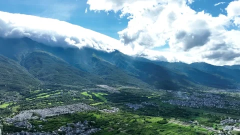 Aerial view of cloud covered green mountain mountain village scenery in Dali Stock Footage 337922052