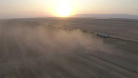 Aerial view with a cloud of dust over a combine at sunset Stock Footage 157092336