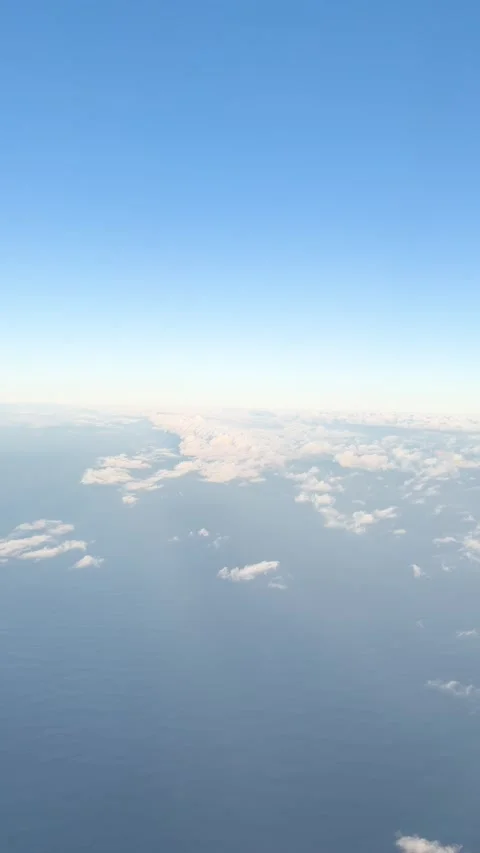Aerial View of Clouds and Blue Sky Through Airplane Window Stock Footage 337994965